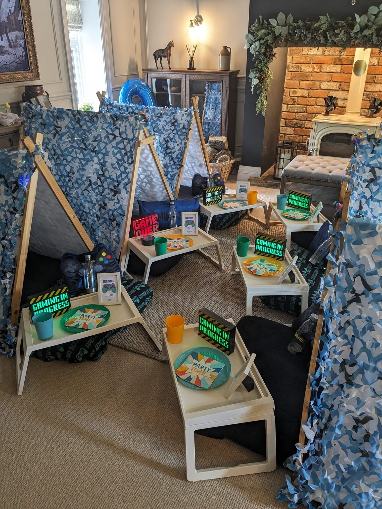 Blue gaming teepees arranged through a living room with individual snack trays