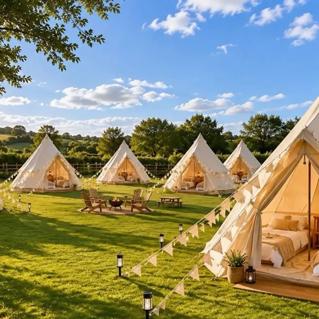A wedding teepee village arranged across a sunny countryside setting
